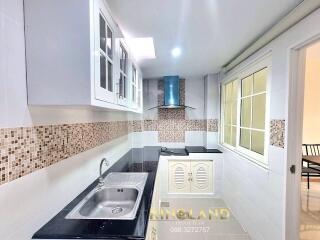 Modern kitchen with granite countertops and mosaic backsplash