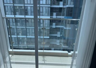 Photo of a balcony with glass railing overlooking neighboring building