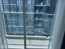 Photo of a balcony with glass railing overlooking neighboring building