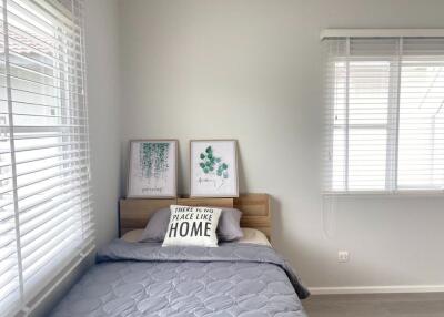 Simple bedroom with bed, wall art, and window