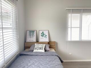 Simple bedroom with bed, wall art, and window