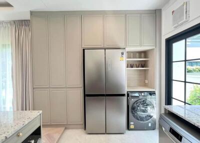 modern kitchen with large refrigerator and washing machine