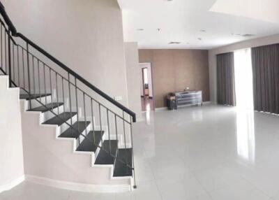 Spacious living room with staircase and large windows