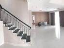 Spacious living room with staircase and large windows