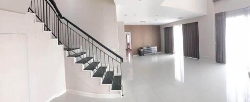 Spacious living room with staircase and large windows