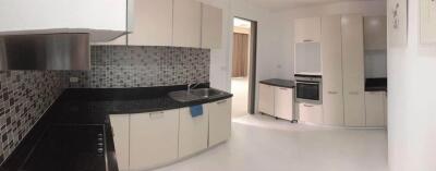 Modern kitchen with white cabinetry and black countertops