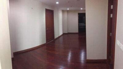 Spacious and well-lit hallway with wooden flooring