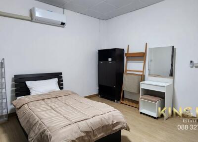 Modern bedroom with single bed, wardrobe, mirror, and air conditioning unit