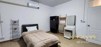 Modern bedroom with single bed, wardrobe, mirror, and air conditioning unit