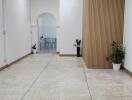 Spacious hallway with plants and a view into another room