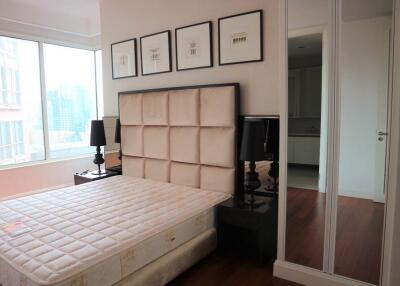 Modern bedroom with large window and artwork above the bed