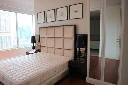 Modern bedroom with large window and artwork above the bed