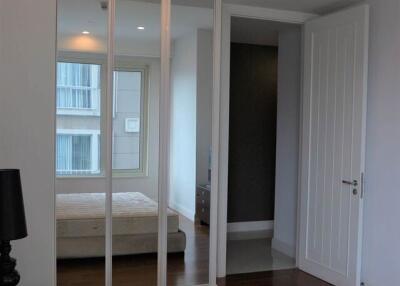 Modern bedroom with large mirror and natural light