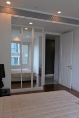 Modern bedroom with large mirror and natural light