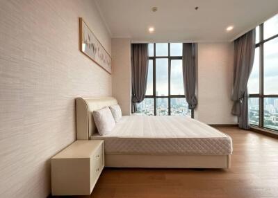 Spacious bedroom with large windows and modern furnishings