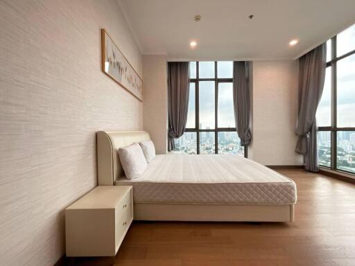 Spacious bedroom with large windows and modern furnishings