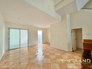 Spacious living room with tiled flooring and natural light