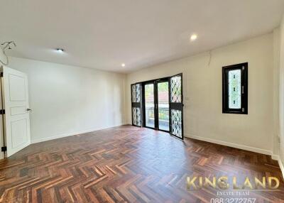 Spacious living room with wooden flooring and large windows