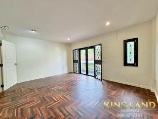 Spacious living room with wooden flooring and large windows