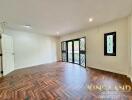 Spacious living room with wooden flooring and large windows