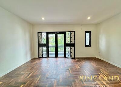 Spacious living room with herringbone wooden flooring and large windows