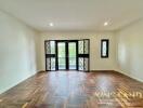 Spacious living room with herringbone wooden flooring and large windows