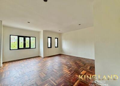 Spacious living room with wooden flooring and large windows