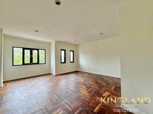 Spacious living room with wooden flooring and large windows