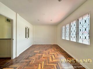 Spacious living area with large windows and parquet flooring