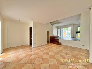 Spacious living area with tiled flooring and natural light