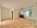 Spacious living area with tiled flooring and natural light