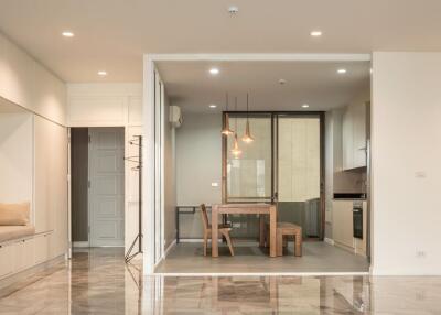 Modern open-plan dining area with wooden furniture and hanging lights