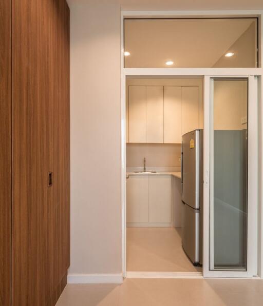 Modern kitchen with a refrigerator and wooden cabinets