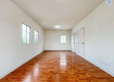 Spacious living room with wooden flooring and large windows