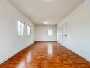 Spacious living room with wooden flooring and large windows