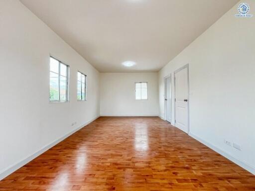 Spacious living room with wooden flooring and large windows