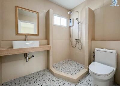 Modern bathroom with a shower, toilet, and sink.