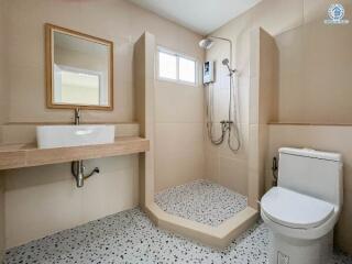 Modern bathroom with a shower, toilet, and sink.