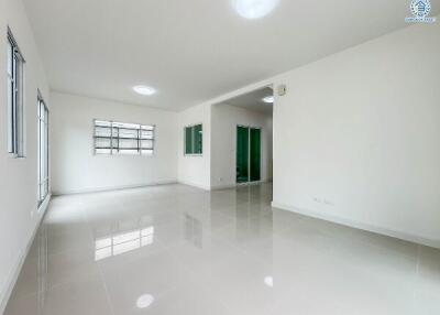 Spacious main living area with large windows and glossy tile flooring