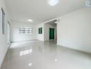 Spacious main living area with large windows and glossy tile flooring