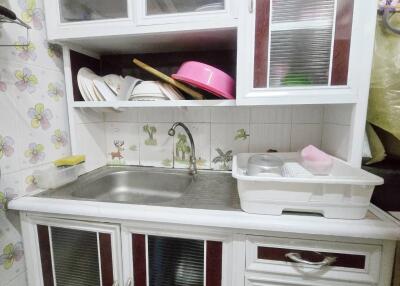 Small kitchen area with sink and storage cabinets