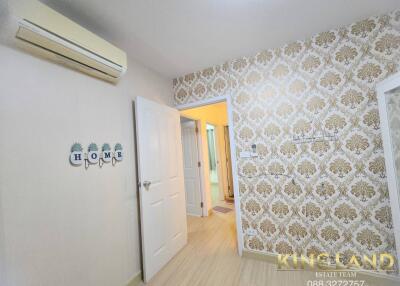 Bedroom with air conditioner, decorative wallpaper, and home decor