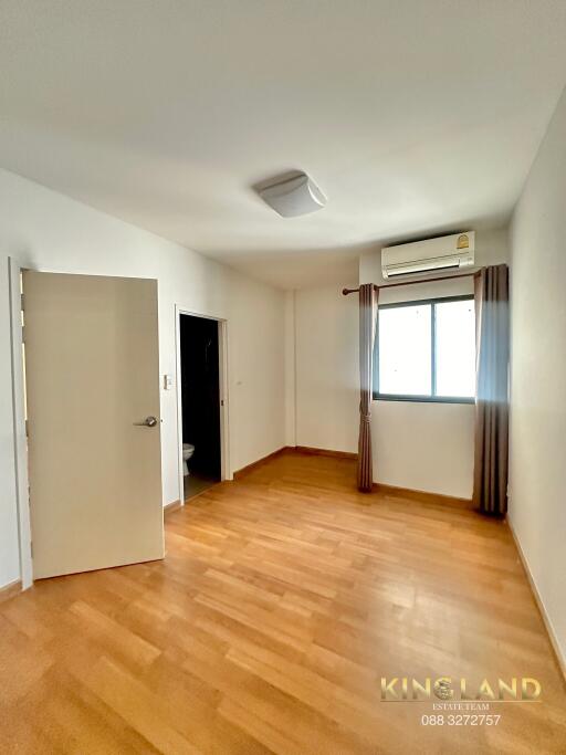 Spacious bedroom with wooden floor and natural light