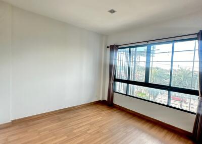 Spacious bedroom with wooden floors and large windows