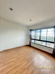 Spacious bedroom with wooden floors and large windows