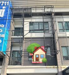 Exterior of a multi-story building with a sign for sale