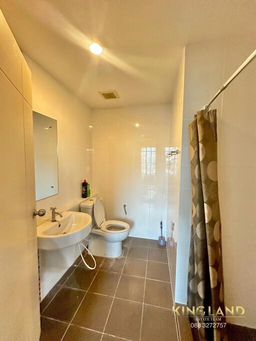 Modern bathroom with tiled flooring and shower curtain