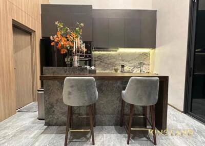 Modern kitchen with marble countertop and two bar stools