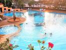 Outdoor swimming pool with people enjoying the water and lounging