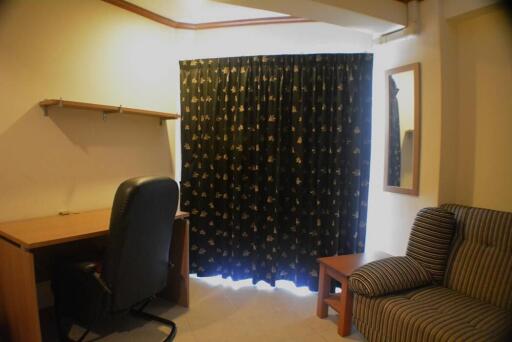 Bedroom with study area and curtain-covered window